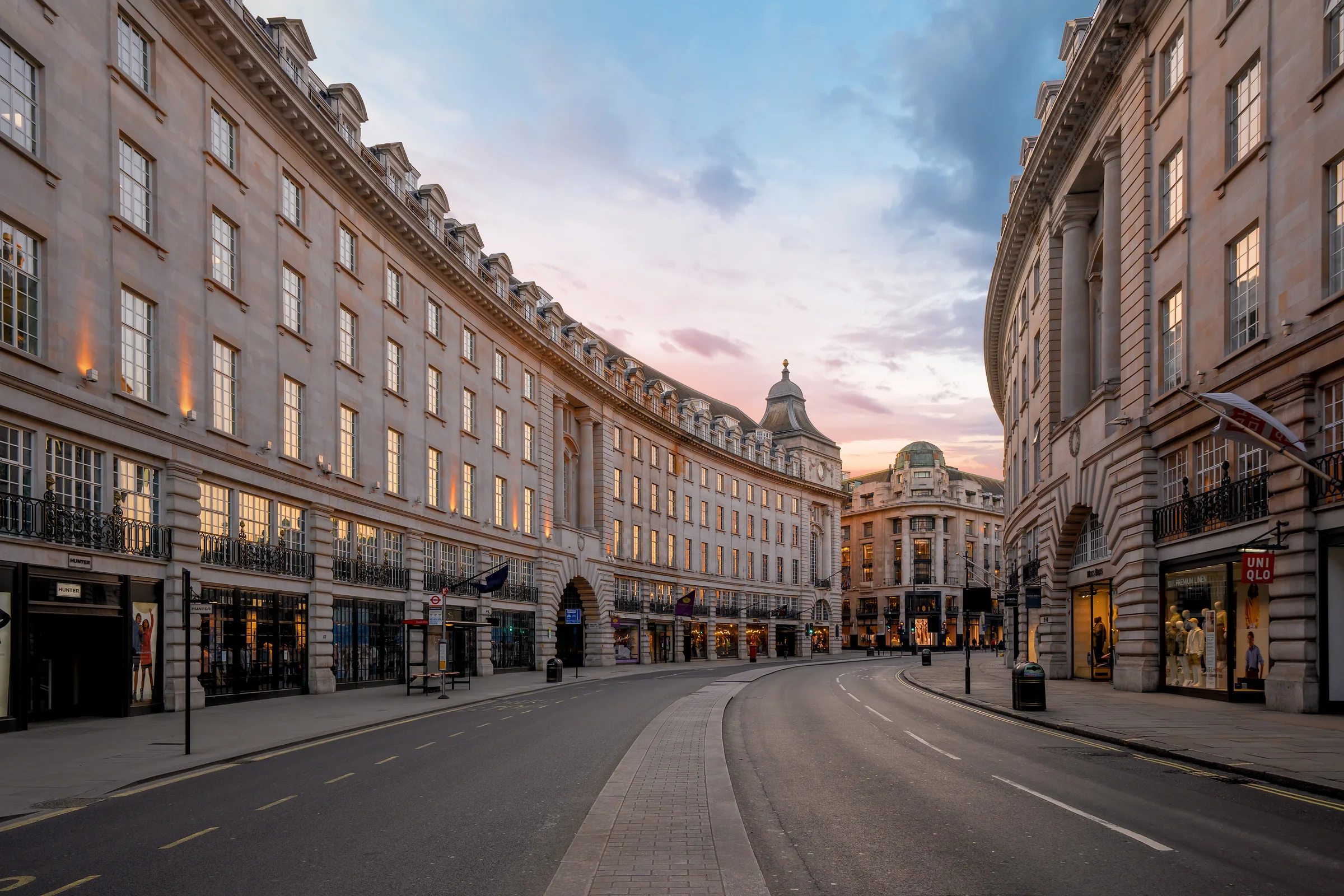 London streetscape at dusk with historic buildings and a curving road